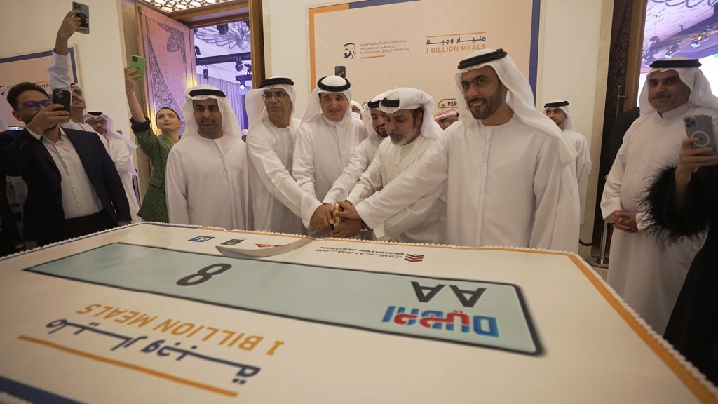 A group of men stand around an image of the AA8 number plate on a cake.