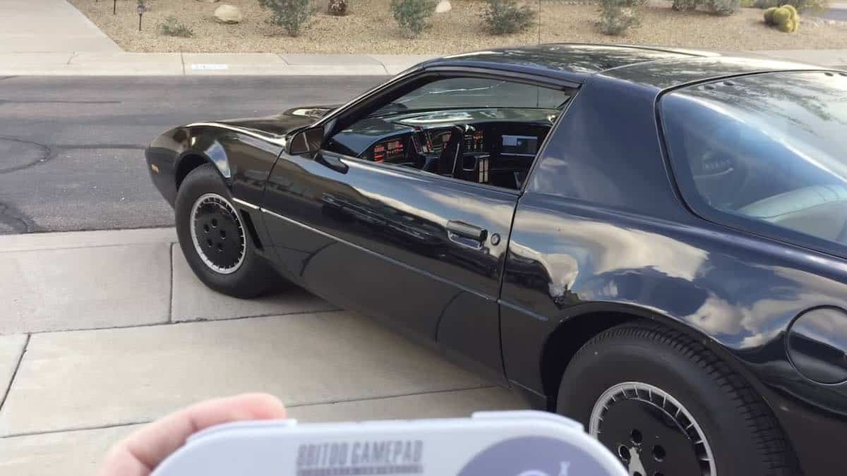 Man driving KITT Pontiac Trans Am with Nintendo Controller